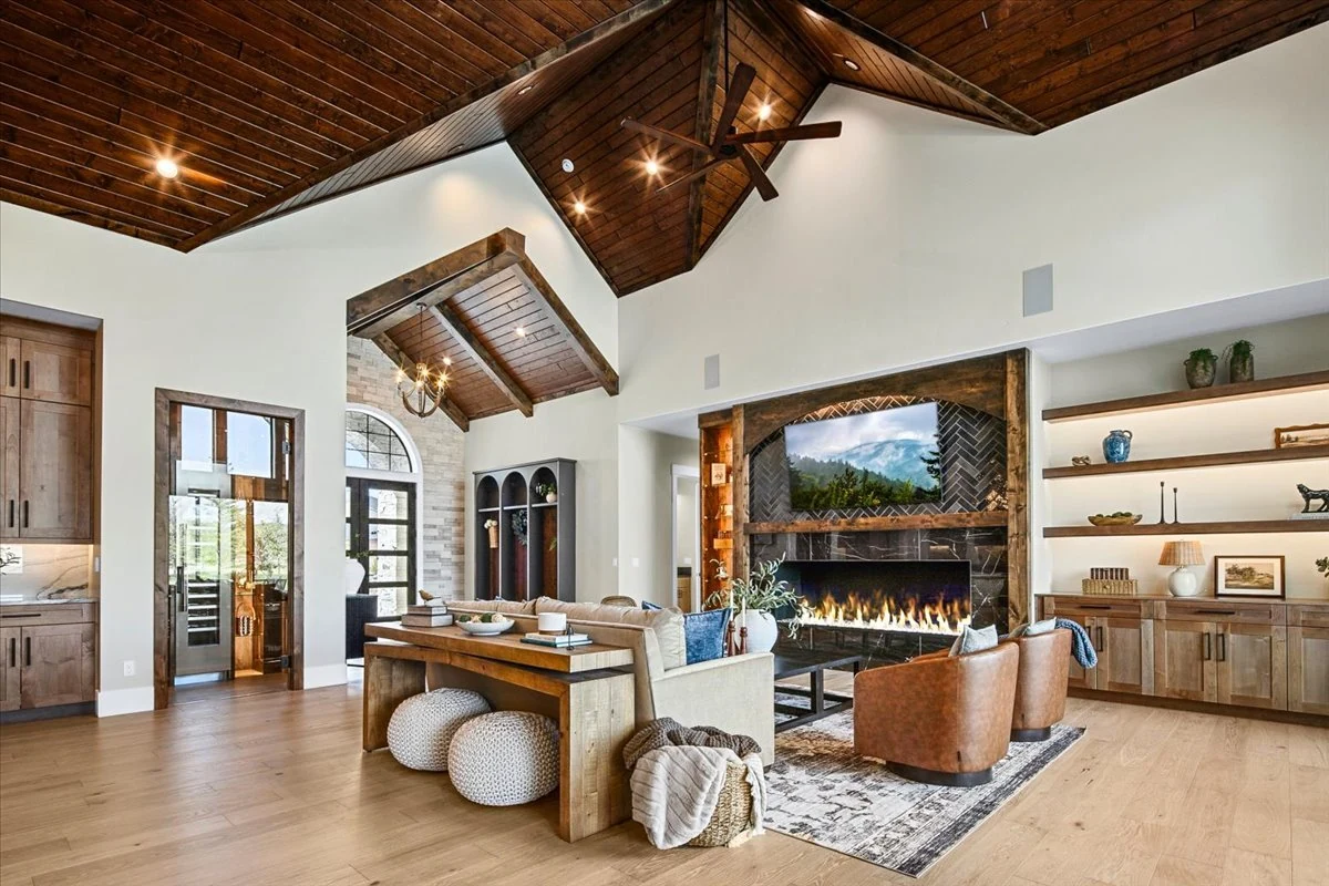 The Jane living room with a timber ceiling, fireplace, built-in shelving and leather seating